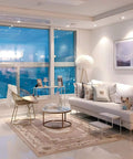 Modern living room with stylish furniture, large window, and a dog on the sofa