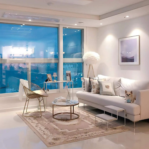 Modern living room with stylish furniture, large window, and a dog on the sofa