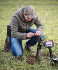 Man using Heavy Duty Serrated Edge Metal Detecting Shovel With Belt Loop Sheath in field with metal detector