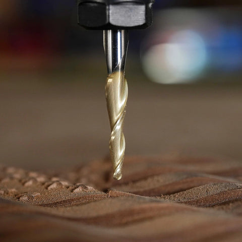 Close-up of SpeTool tapered ball-nose end mill with 1/4 in shank and 1/32 in radius, gold ZrN coating cutting into wood.