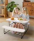 Girls seated at white picnic table with benches indoors, using Picnic Table With Benches Set For Outdoor And Indoor Use All Weather Steel Frame Stable And Easy To Clean Your Go To Portable Camp Table And Chairs Fold Flat Lightweight And Durable.