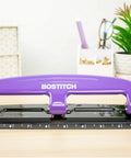 EZ Squeeze Reduced Effort 3 Hole Punch for busy office, purple finish, showing integrated ruler and durable metal construction on desk