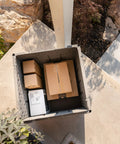 Versatile Outdoor Storage Cube Deck Box Doubles As Cozy Bench Seat And 25 Gallon Capacity Weather Resistant Patio Organizer with packages inside.
