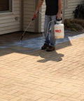 Man applying Premium Patio Paver Sealer Low Gloss Water Based Clear Stone Sealant Tough As Nails For Driveways with sprayer.