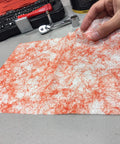 Person holding a Grease Busting Heavy Duty Hand And Tool Wipe for Degreasing Hands And Work Surfaces near tools