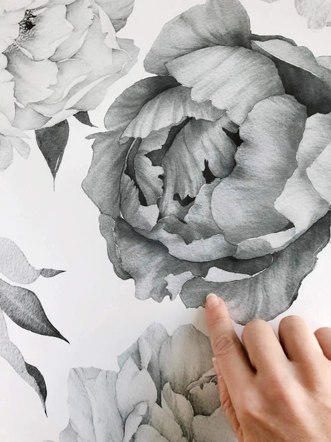 Hand showing the Easy Peel And Stick Black And White Peony Watercolor Wall Decals Set Of 8 For Bedroom And Living Room close-up