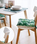 Dining table with tropical leaf cushion on wooden chair in modern home setting