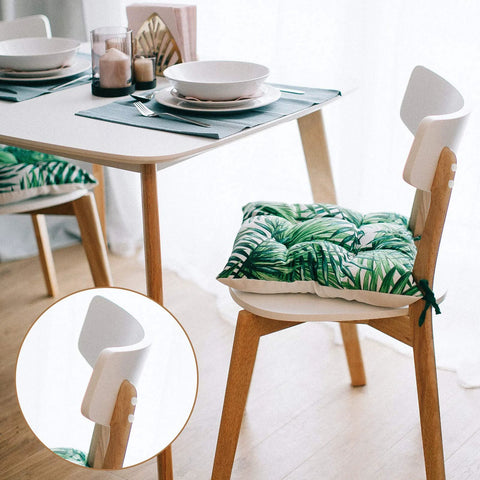 Dining table with tropical leaf cushion on wooden chair in modern home setting