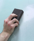 Hand using Pro Grade Sanding Sponges Pack Three By Five By One Inch Medium And Fine Grit for contours and flat surfaces