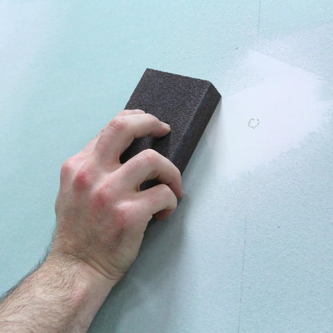 Hand using Pro Grade Sanding Sponges Pack Three By Five By One Inch Medium And Fine Grit for contours and flat surfaces