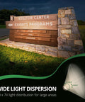 Outdoor Security Flood Light With 15W LED, 1370 Lumens highlighting visitor center sign with 7H x 7V light dispersion diagram.
