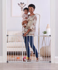 Mom with child standing behind Easy Open Extra Wide Baby Gate For Doorways Hallways And Bottom Of Stairs 29 To 47 Inches Pressure Mounted Safety Gate For Babies Toddlers And Pets Mom Approved American Designed And Family Owned.
