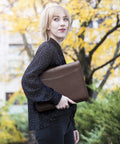 Woman holding the Career Game Changer Business Padfolio With Heavy Duty Zipper Closure Crafted From Smooth Pu Vegan Leather in rich brown.