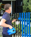 Man using High Power HVLP Electric Paint Sprayer With 800 Milliliter Per Minute Output on blue fence