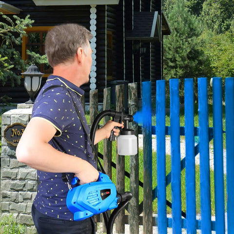 Man using High Power HVLP Electric Paint Sprayer With 800 Milliliter Per Minute Output on blue fence