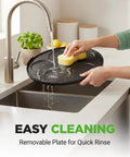 Washing a 12-inch nonstick plate from Electric Crepe Maker And Griddle under running water in a kitchen sink.