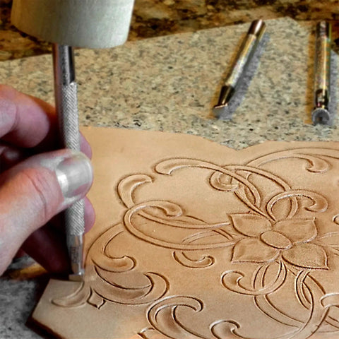 Level Up Your Leather Crafting Game With This Sweet Beginner Tooling Kit Featuring A Sharp Swivel Knife Six Essential Stamps Veg Tan Patterns And A Nifty Instructional Booklet For Dope Custom Designs, depicting a hand using a swivel knife on a leather piece.