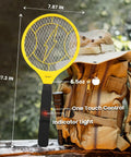 Electric Fly Swatter Racket with 3000V mesh and high-visibility yellow handle beside a tan backpack, one-touch control visible.
