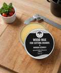 Food Grade Beeswax Wood Polish For Cutting Boards And Butcher Blocks in a round tin, placed on a wooden cutting board.