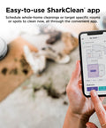 Person using app to control Matrix Clean Robot Vacuum With Serious Suction For Pet Hair On Carpets And Hard Floors Self Empty Base 60 Day Dust Capacity Voice Control LiDAR Navigation And Smart Mapping For Effortless Home Cleaning on smartphone in a living room.