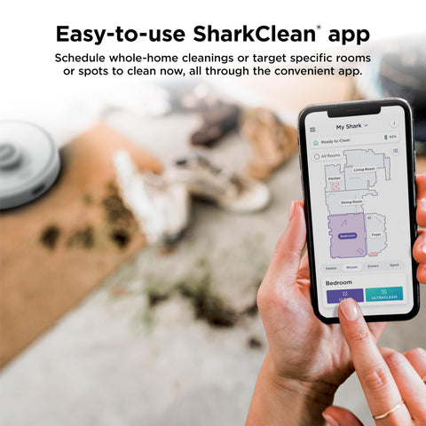 Person using app to control Matrix Clean Robot Vacuum With Serious Suction For Pet Hair On Carpets And Hard Floors Self Empty Base 60 Day Dust Capacity Voice Control LiDAR Navigation And Smart Mapping For Effortless Home Cleaning on smartphone in a living room.