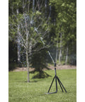 Heavy Duty Tripod Sprinkler With Round Base And Brass Head, spraying water over lawn, showing adjustable height and stability.