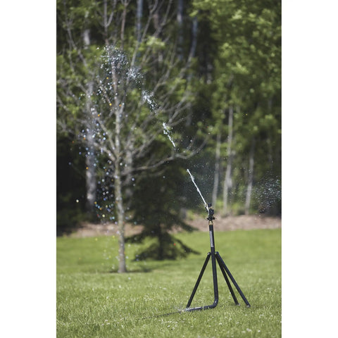 Heavy Duty Tripod Sprinkler With Round Base And Brass Head, spraying water over lawn, showing adjustable height and stability.