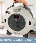 Close-up of 25 Ft Retractable Extension Cord Reel With 4 Outlets, 2 USB Ports, ergonomic handle, in hand