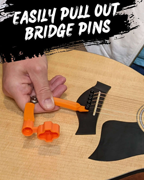 Guitar tool, orange plastic 3-in-1 with string winder and bridge-pin puller on an acoustic guitar