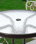 Outdoor table with Two Pack 2 Inch Parasol Umbrella Hole Ring Plug And Cap Set installed, clear top, surrounded by garden chairs.