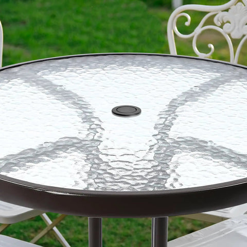 Outdoor table with Two Pack 2 Inch Parasol Umbrella Hole Ring Plug And Cap Set installed, clear top, surrounded by garden chairs.