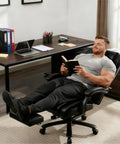 Person reclining in Big And Tall Leather Reclining Office Chair With Retractable Footrest And Adjustable Lumbar Support, Heavy Duty 500 Lb Capacity, Ergonomic Desk Chair For Home Office, Work Or Relaxation, Black
