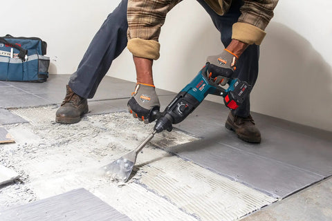 Worker using 5 In. By 11 In. SDS-Plus Bulldog Floor Scraper With Durable Steel Blade for tile removal on floor surface