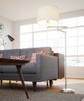 Theta Swing Arm Floor Lamp With Brushed Steel Finish beside gray sofa in modern living room.