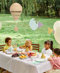 Children's outdoor party with Rattan Woven Hot Air Balloon Wall Decor For Kids Room Cute Nursery Hanging Ornament. Cozy, boho style.