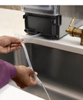 No Cap Portable Nugget Ice Maker Countertop Machine connects water line for easy filling near sink.