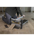 User kneeling with 13 Inch Heavy Duty Lvp Flooring Cutter With Built In Led Light and Reinforced Steel Table, cutting vinyl planks on the floor.