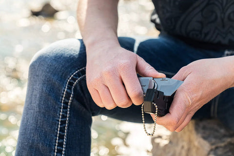 Person holding Compact 2.5 Inch Folding Keychain Knife With 1.75 Inch Modified Tanto Blade And G10 Handle for tactical use