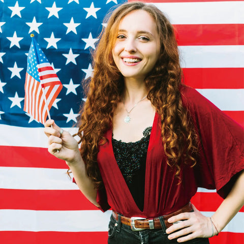 Woman holding 4x6 inch mini American flag in front of large USA flag, Fourth Of July Flags On Sticks 4x6 Inch Mini American USA Flags.