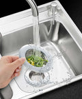 Hand holding Two Pack Stainless Steel Kitchen Sink Strainer Set With Large Wide Rim Four Point Five Inch Diameter Micro Perforated