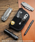 EDC Pouch With Ten Compartments Small Pocket Tool Organizer For Multitools Men DIY Patches Area Durable Everyday Carry Case With Black Or Orange Interior Compact Size For Quick Access And Organization on wooden surface with multitools and flashlight