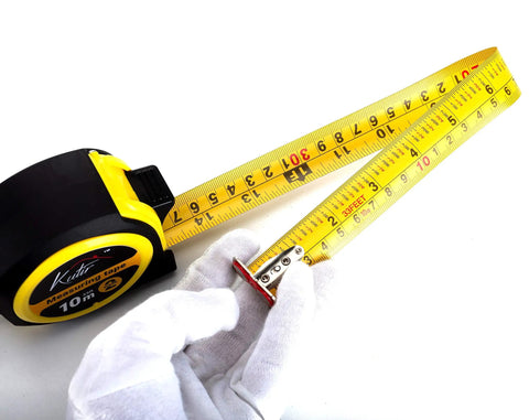 33 Ft Tape Measure With Magnetic Hooks And Fraction Markings Retractable Dual Sided Ruler being extended by a gloved hand