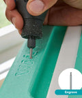 Rotary tool with engraving bit engraving a green plastic surface; front view