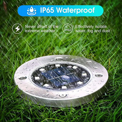 Solar Disk Lights For Outdoor Landscaping And Pathways No Fuss LED Easy Stake Mount Waterproof Stainless Steel Tops Rust Free Garden Lights 8 Pack showing waterproof disk light in rain on grass