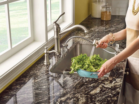 Woman rinsing lettuce with faucet near Deck Mounted Kitchen Soap Dispenser With 18 Ounce Refillable Bottle Easy Lift Off Top Spot Resist