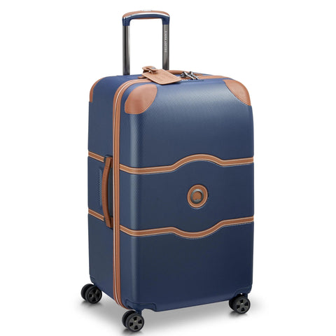 Delsey 26-inch spinner luggage in navy blue with faux leather accents and basketweave texture, featuring durable polycarbonate shell with wheels.