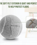Close-up of precut tennis ball showing rubber interior and soft felt exterior for furniture leg protection on hardwood floors.