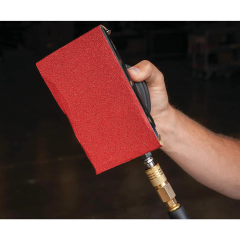 Top Shelf Pneumatic Orbital Sander With Built In Air Regulator And Rubber Over Mold Grip held in hand, showing sanding block detail.