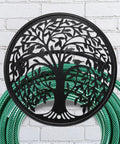 Heavy Duty Outdoor Garden Hose Reel and Wall Mount Holder With Tree of Life Metal Design on brick wall with green hose