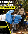 Close-up of a silver 420 motorcycle chain held by a blue-gloved hand, ATV rider in background